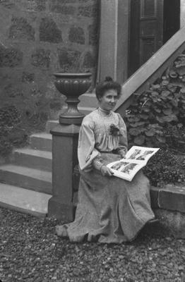 Edwardian woman in garden with photograph album